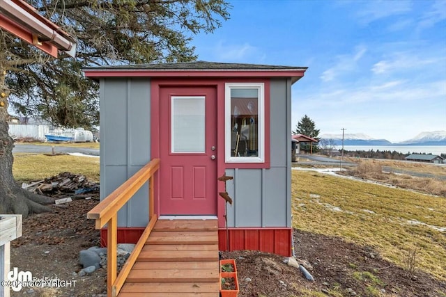 view of outdoor structure featuring entry steps and a water and mountain view