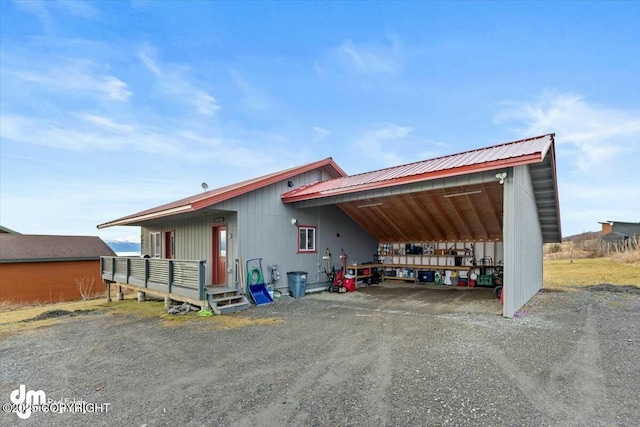 exterior space with an attached carport, metal roof, and driveway