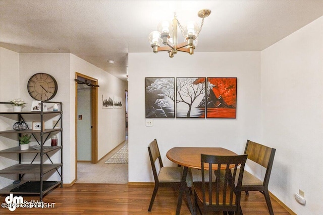 dining room with baseboards, an inviting chandelier, and wood finished floors