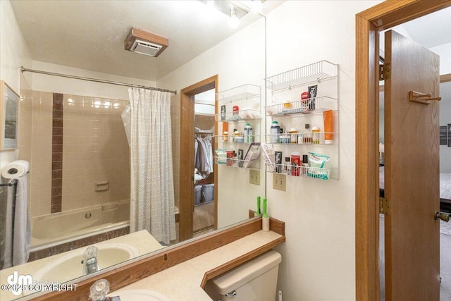 bathroom featuring a sink, shower / tub combo with curtain, and toilet