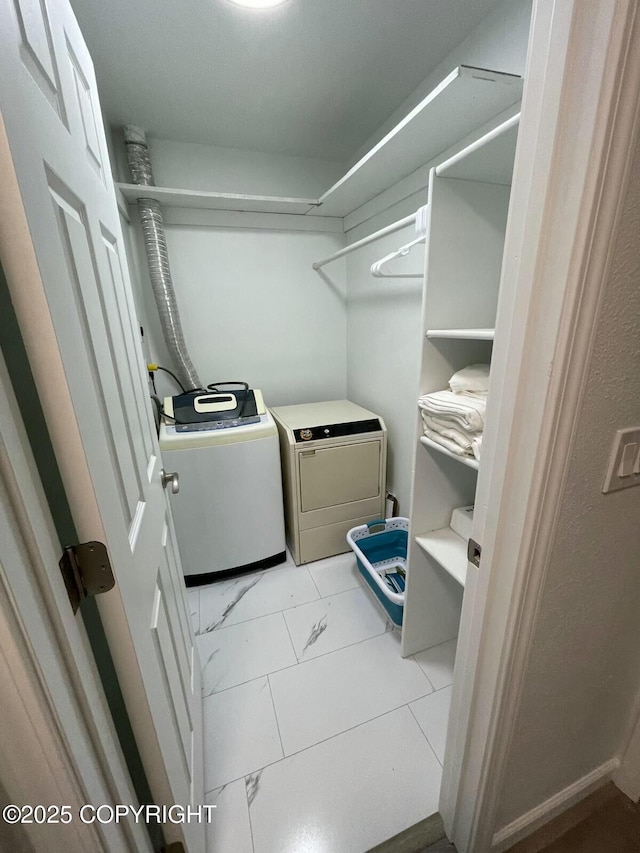 laundry room featuring laundry area, marble finish floor, and washer and clothes dryer