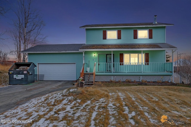 traditional home featuring a porch, driveway, and a garage