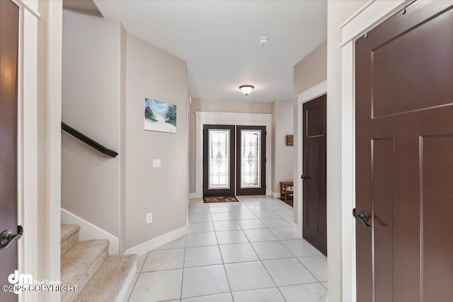 entryway with french doors, stairway, baseboards, and light tile patterned floors