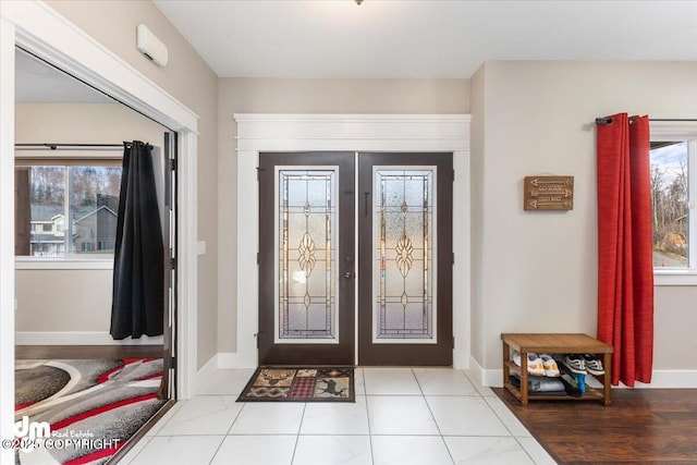 entryway with baseboards and french doors