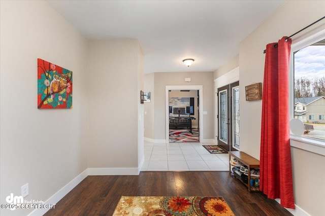 hall with french doors, wood finished floors, and baseboards