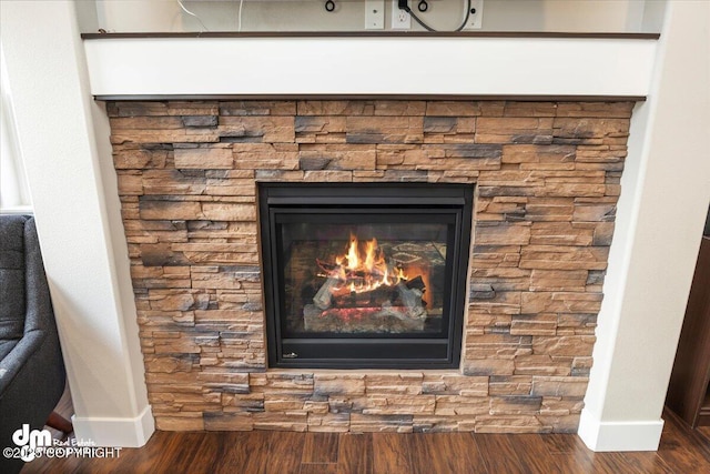 room details with a fireplace, wood finished floors, and baseboards