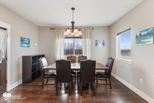 dining space featuring dark wood-style floors, an inviting chandelier, and baseboards