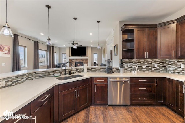 kitchen featuring open shelves, a healthy amount of sunlight, a sink, a stone fireplace, and dishwasher