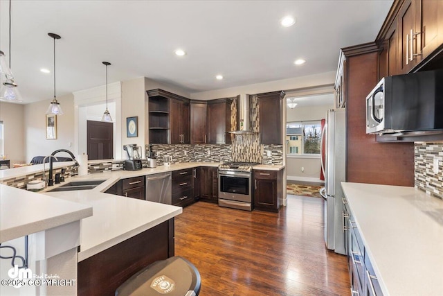 kitchen with open shelves, appliances with stainless steel finishes, a sink, wall chimney range hood, and dark brown cabinetry