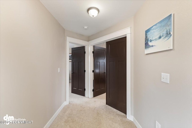 corridor featuring light carpet and baseboards