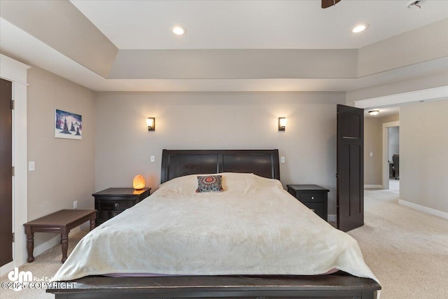 bedroom with baseboards, recessed lighting, a raised ceiling, and light colored carpet