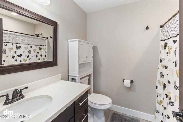 full bathroom featuring toilet, a shower with shower curtain, vanity, and baseboards