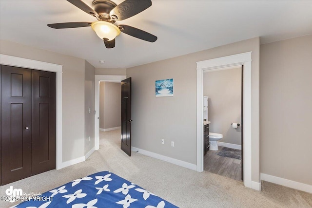 bedroom with light carpet, ceiling fan, ensuite bath, and baseboards