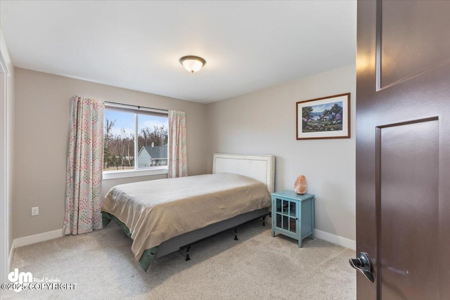 bedroom with light carpet and baseboards