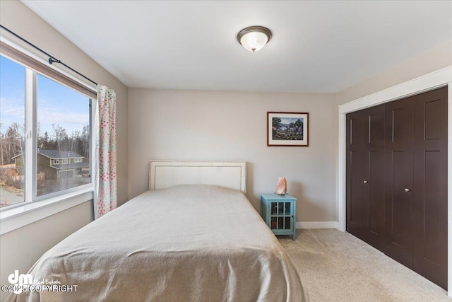 bedroom featuring carpet, baseboards, and a closet