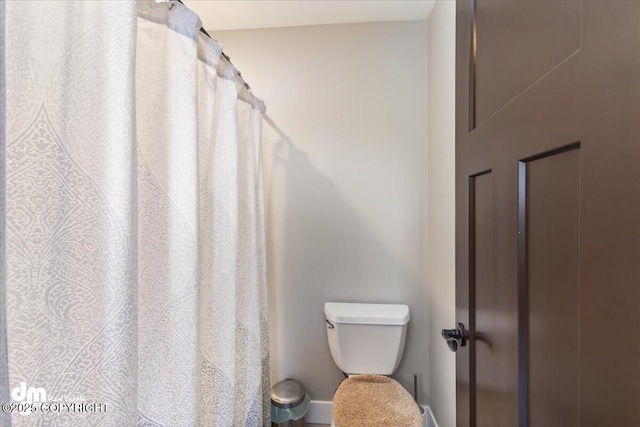 full bathroom featuring a shower with shower curtain and toilet