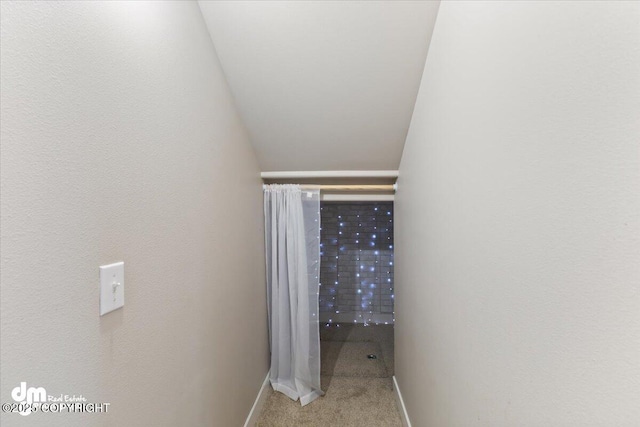 corridor with carpet flooring and baseboards