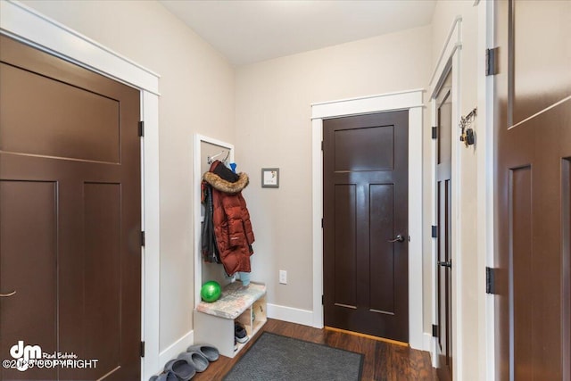 mudroom with dark wood-style floors and baseboards