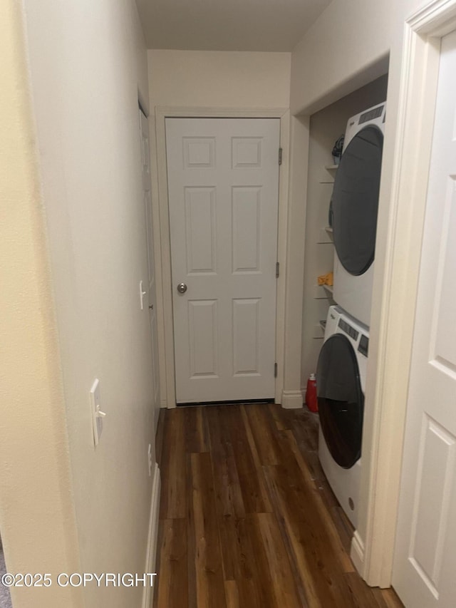 laundry room featuring dark wood-style floors, laundry area, and stacked washer / dryer