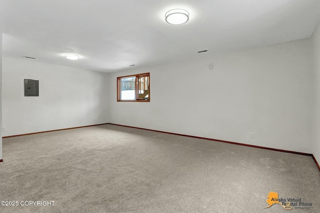 spare room with carpet floors, electric panel, and baseboards