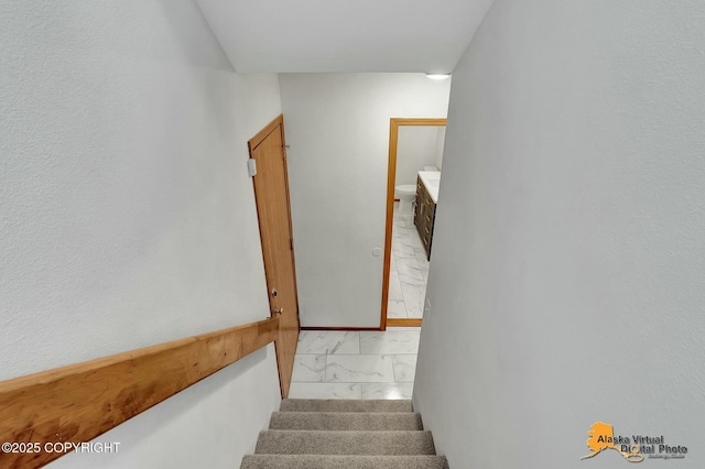 stairway featuring marble finish floor