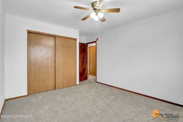 unfurnished bedroom featuring a closet, light colored carpet, ceiling fan, and baseboards