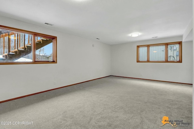 carpeted spare room with visible vents and baseboards