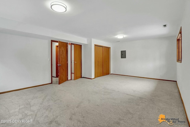 unfurnished room with light carpet, electric panel, and baseboards