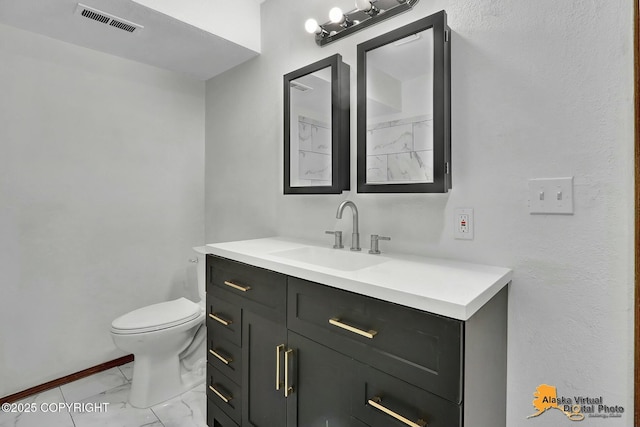 bathroom with toilet, marble finish floor, visible vents, and vanity