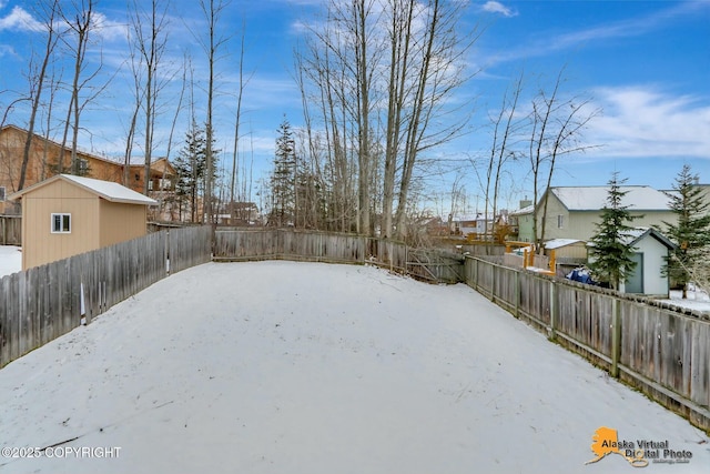 yard layered in snow with a residential view and a fenced backyard