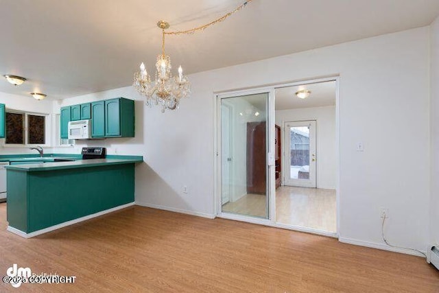 kitchen with pendant lighting, light wood finished floors, a baseboard radiator, white appliances, and a peninsula