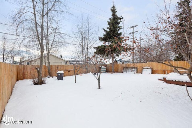 yard covered in snow with a fenced backyard