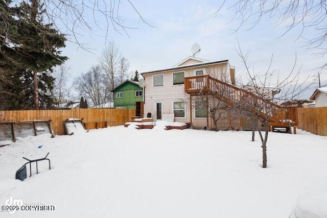 snow covered property featuring fence, a wooden deck, and stairs