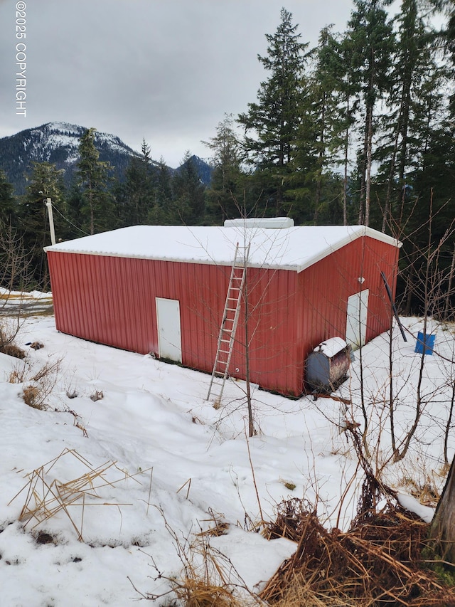 yard layered in snow featuring a mountain view