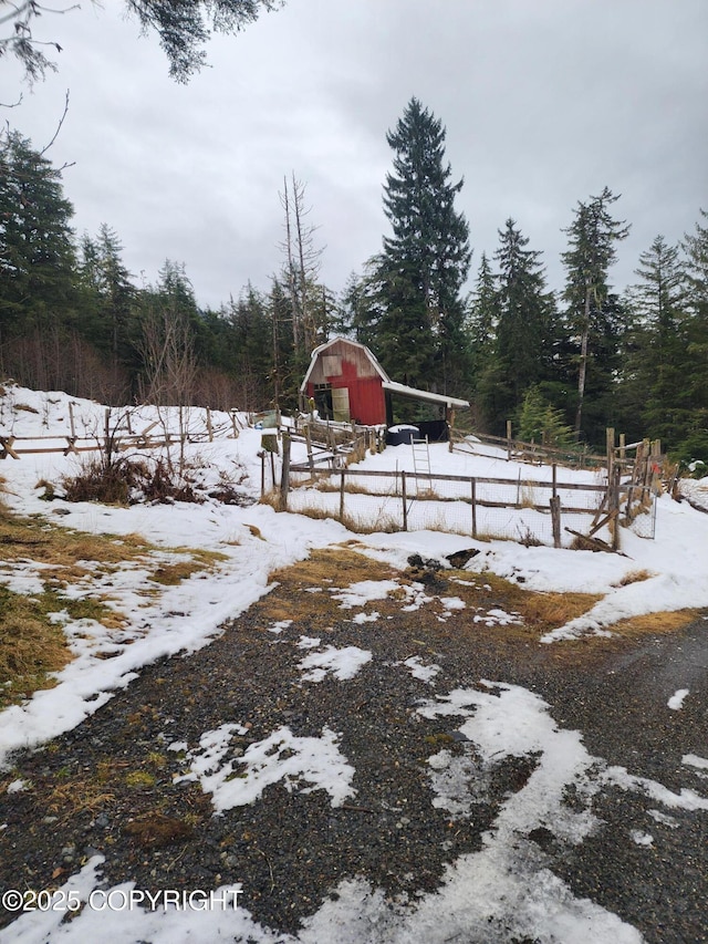 yard covered in snow with an outdoor structure and a barn