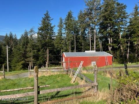 469 Mitkof Hwy, Petersburg, AK 99833 - view of pole building with fence and a forest view