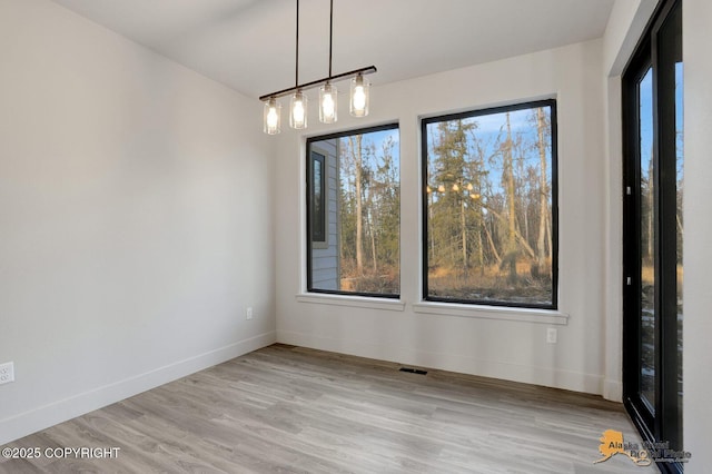 spare room with visible vents, baseboards, and wood finished floors