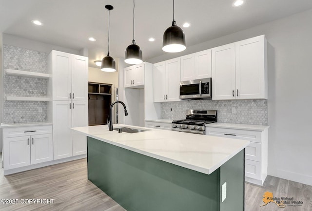 kitchen with appliances with stainless steel finishes, white cabinets, a sink, and open shelves