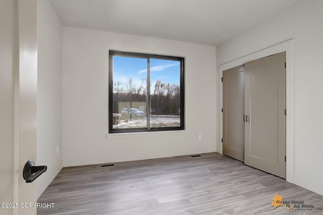 unfurnished bedroom with light wood finished floors and baseboards