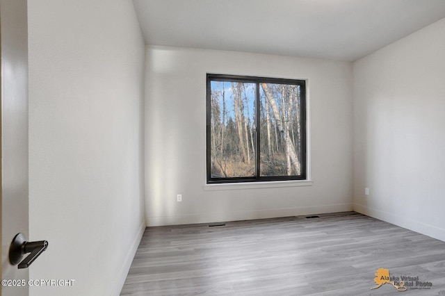 empty room featuring baseboards and wood finished floors