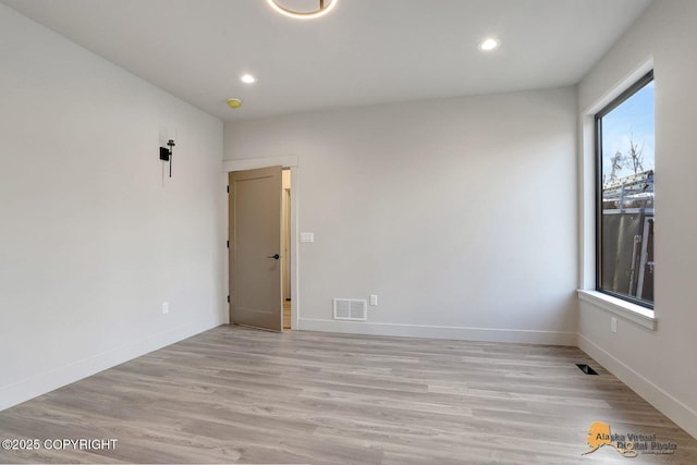 spare room featuring light wood-type flooring, baseboards, visible vents, and recessed lighting