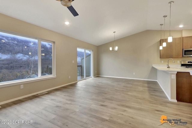 interior space featuring lofted ceiling, plenty of natural light, light wood-style flooring, and visible vents