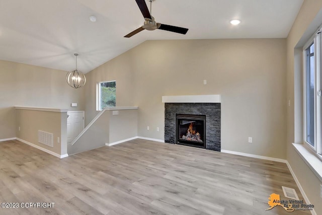 unfurnished living room with vaulted ceiling, light wood finished floors, and visible vents