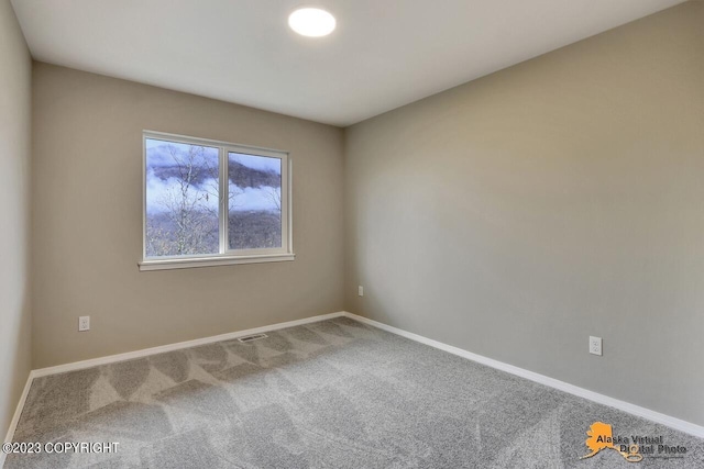 carpeted empty room featuring visible vents and baseboards