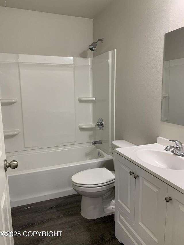 bathroom with toilet, shower / bath combination, wood finished floors, and vanity