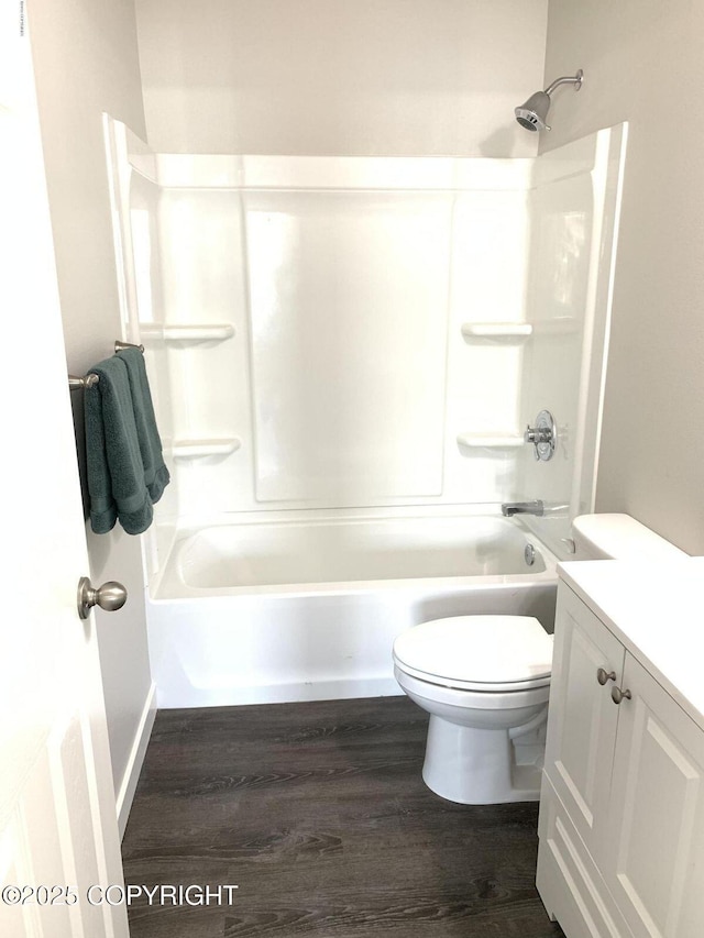 bathroom with vanity, bathtub / shower combination, wood finished floors, and toilet