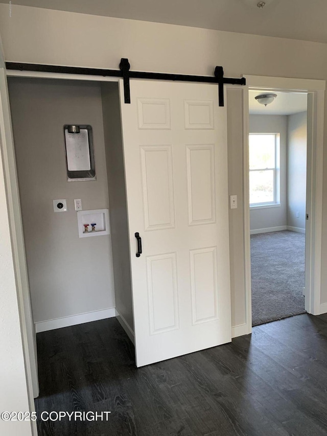 washroom featuring hookup for a washing machine, a barn door, dark wood-type flooring, electric dryer hookup, and laundry area