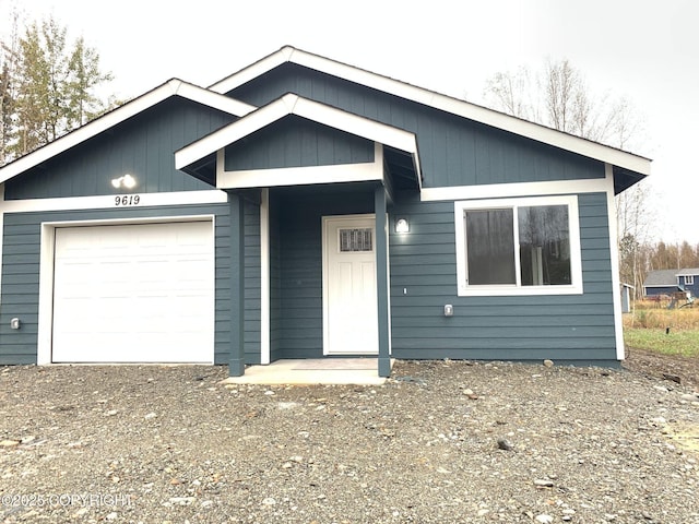 view of front of house with dirt driveway and an attached garage