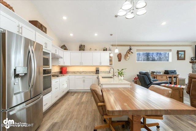 kitchen featuring light countertops, appliances with stainless steel finishes, hanging light fixtures, and white cabinetry