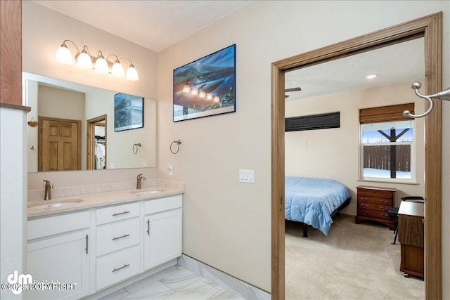 full bath with a sink, double vanity, baseboards, and connected bathroom